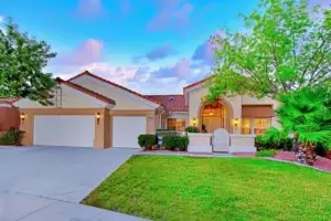 Buckingham Floor Plan in Sun City Summerlin front exterior with three-car garage, arched entryway, and landscaped yard.
