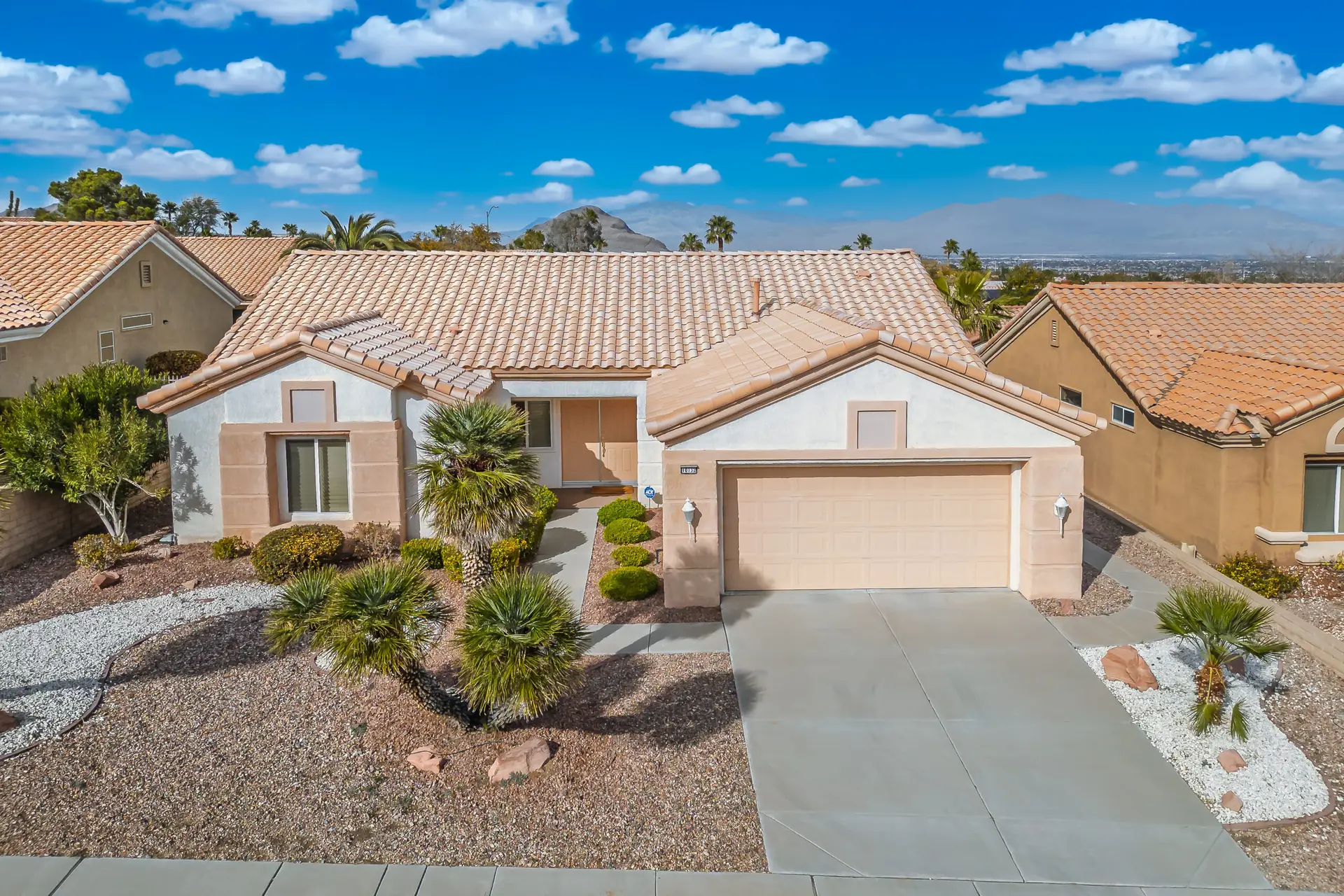 Minden Floor Plan in Sun City Summerlin front exterior with desert landscaping, tile roof, and mountain views in the background.