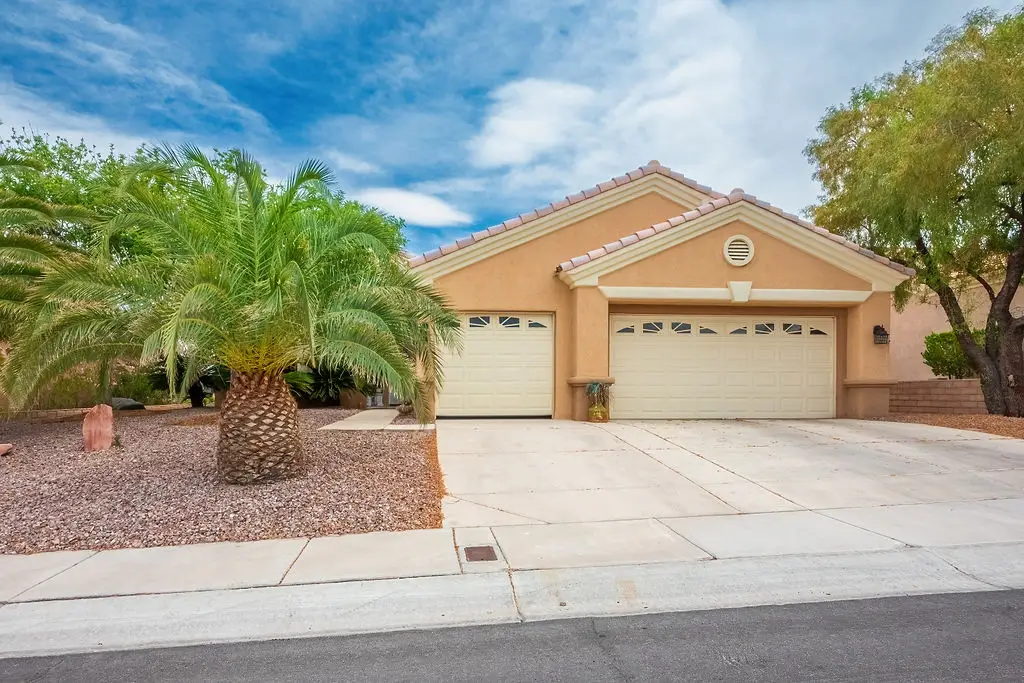 Sherwood Floor Plan in Sun City Summerlin front exterior with desert landscaping, brick accents, and covered entryway.